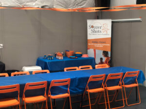 Tables and chairs set up and ready for cake and treats for child's birthday party at indoor facility.