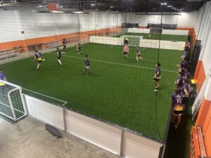 Youth indoor soccer league playing at Total Soccer Center facility.